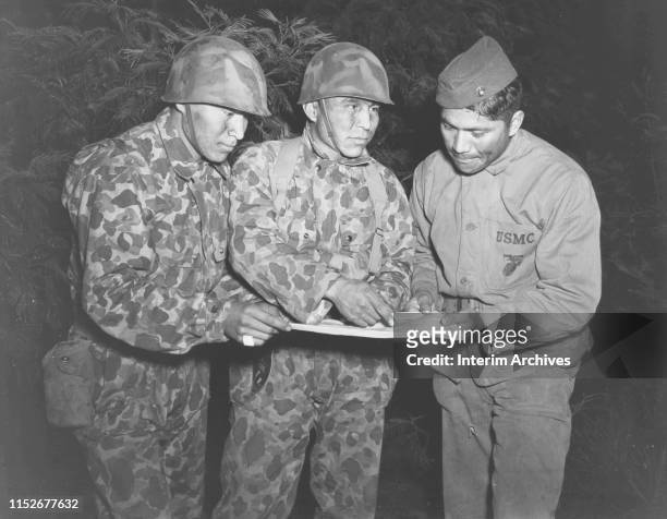 Private First Class Peter Nahaidinac, left, Private First Class Joseph Gatewood, and Corporal Lloyd Oliver, who are native American Navajos, study a...