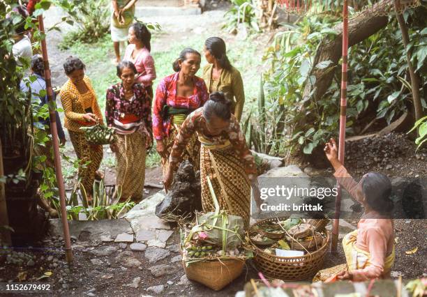 nostalgia. bali indonesia, kuta beach 1978 traditionally dressed balinese women are preparing offerings to the temple, - kuta stock pictures, royalty-free photos & images