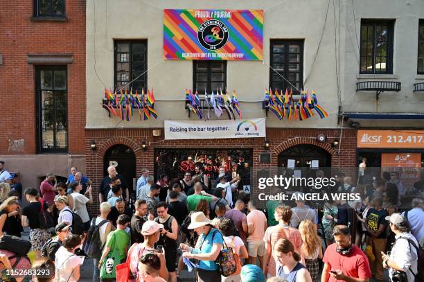 People gather outside the Stonewall Inn to mark the 50th anniversary of the Stonewall Riots in New York, June 28, 2019. - The June 1969 riots,...