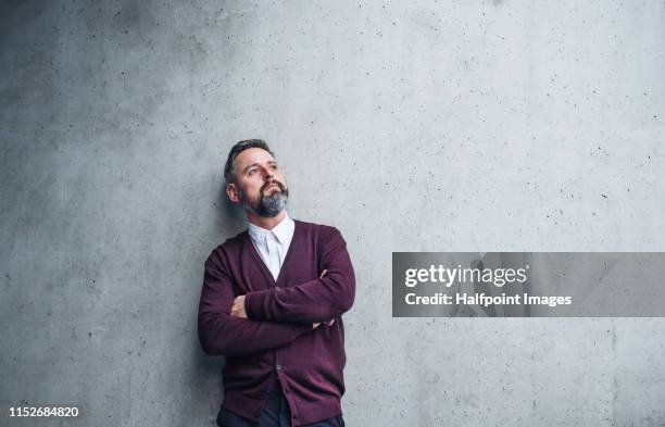 a waist up portrait of serious mature businessman standing against a concrete wall. copy space. - camisa cinzenta - fotografias e filmes do acervo