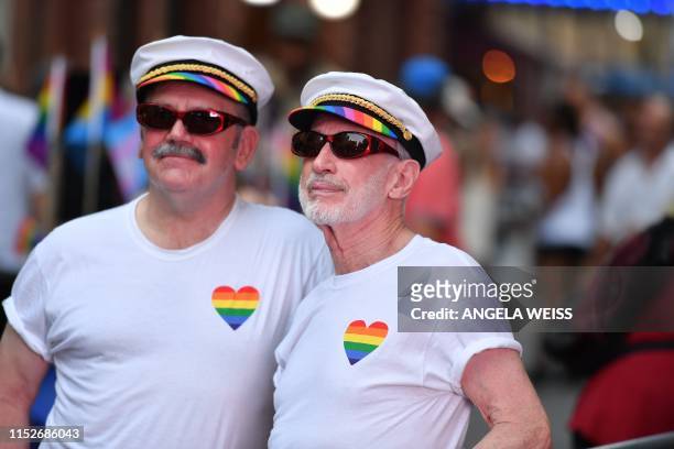 Two men pose for a picture as people gather outside the Stonewall Inn during a rally to mark the 50th anniversary of the Stonewall Riots in New York,...