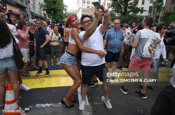 People take pictures as they gather for the 50th anniversary of the Stonewall Riots in front of the Stonewall Inn in New York ON June 28, 2019 . -...