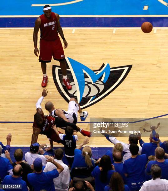 Dwyane Wade of the Miami Heat fouls Jason Kidd of the Dallas Mavericks as Wade falls into the front row in the second quarter of Game Three of the...