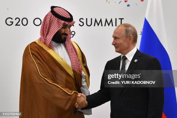 Russia's President Vladimir Putin shakes hands with Saudi Arabia's Crown Prince Mohammed bin Salman during a meeting on the sidelines of the G20...