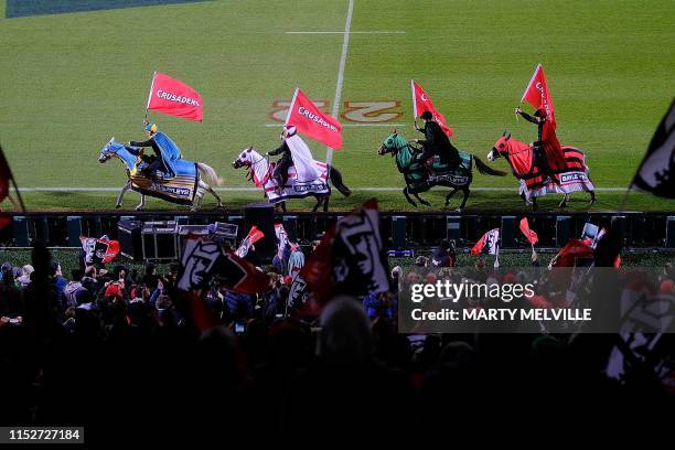 Horses with Crusaders' flags parade on the pitch before the Super Rugby semi-final match between New Zealand's Crusaders and Hurricanes in...