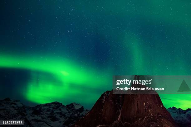 silhouette of couple hiker on mountain with aurora background. - noorderlicht sterren stockfoto's en -beelden