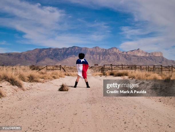 man wrapped in texas flag looking toward a mountain - parque nacional de las montañas de guadalupe fotografías e imágenes de stock