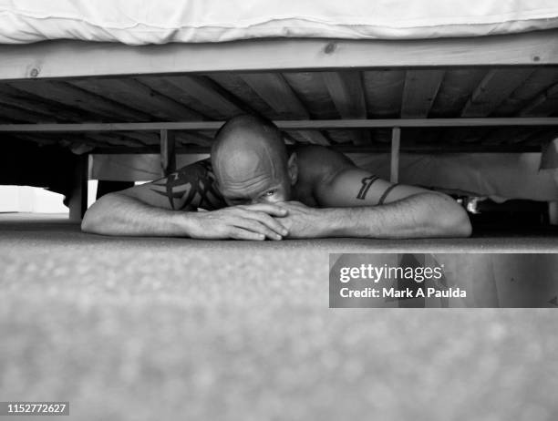 man covering eyes and hiding under a bed - se cacher photos et images de collection