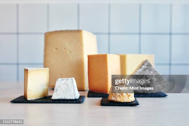 still life of a range of cheeses on table top - cheeses imagens e fotografias de stock