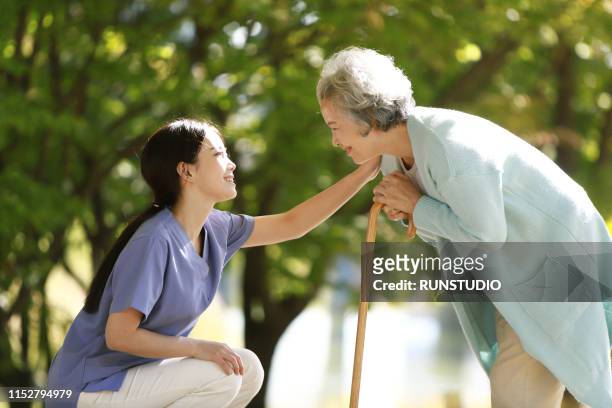 nurse helping senior woman with cane - grandma cane stock pictures, royalty-free photos & images