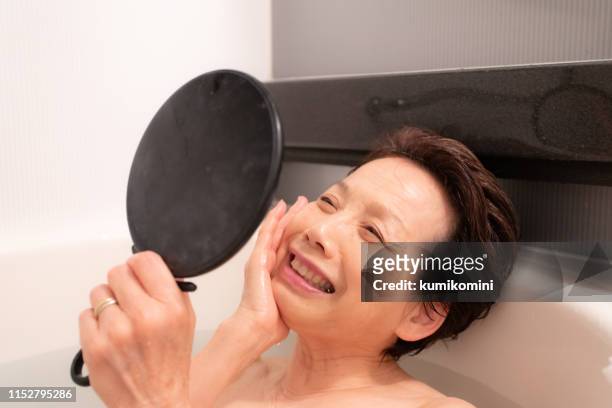 seniorin entspannt im bad - mirror steam stock-fotos und bilder
