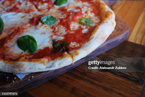 hot pizza margarita on wooden table in cafe. lunch. italian cuisine. copy space. - pizza crispy stock-fotos und bilder