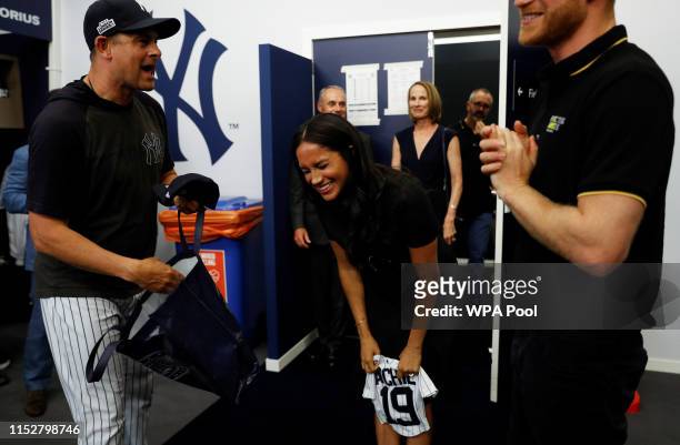 Manager Aaron Boone of the New York Yankees presents a gift for Archie to Prince Harry, Duke of Sussex and Meghan, Duchess of Sussex before their...