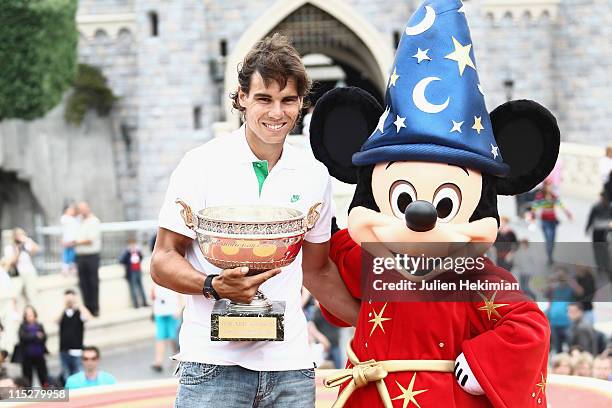 Rafael Nadal poses with the winner of the Men's Singles cup, named 'La Coupe des Mousquetaires' after winning his sixth victory at the French Open at...