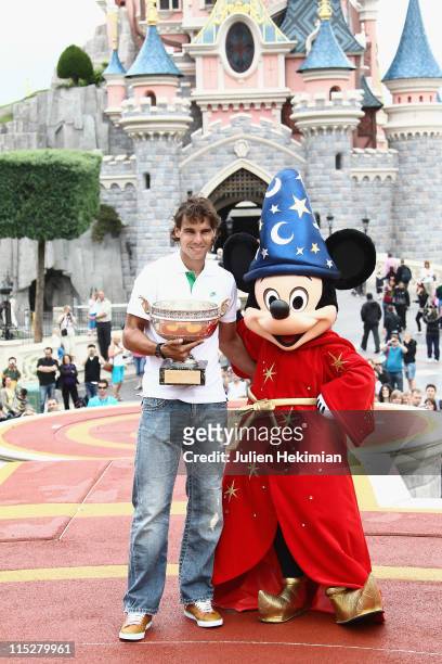 Rafael Nadal poses with the winner of the Men's Singles cup, named 'La Coupe des Mousquetaires' after winning his sixth victory at the French Open at...