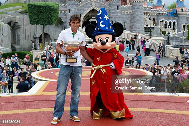 Rafael Nadal poses with the Roland Garros French Tennis Open trophy and Micky Mouse during a photocall at Disneyland Hotel on June 6, 2011 in Paris,...