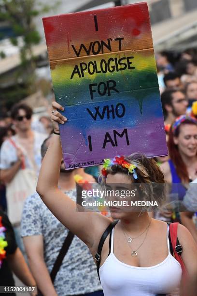 Woman holds a placard as people parade during the Milan Pride 2019 on June 29, 2019 in Milan, as part of the LGBT Pride month marking the 50th...