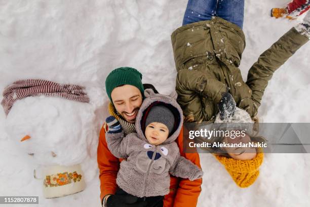 posiieren mit unserem snowman - baby eltern von oben stock-fotos und bilder