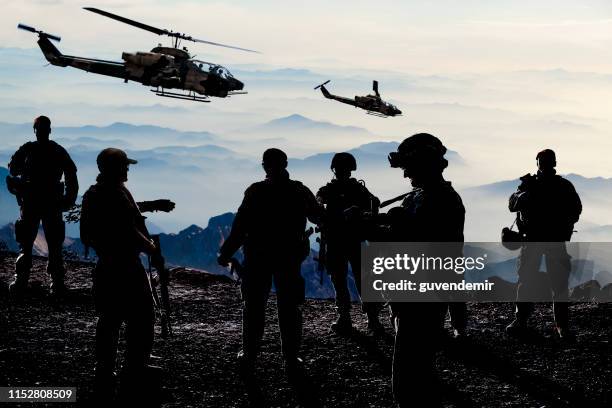 sagome di soldati durante la missione militare al crepuscolo - campo di battaglia foto e immagini stock