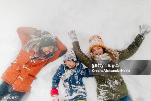 het maken van snow angels - winter stockfoto's en -beelden