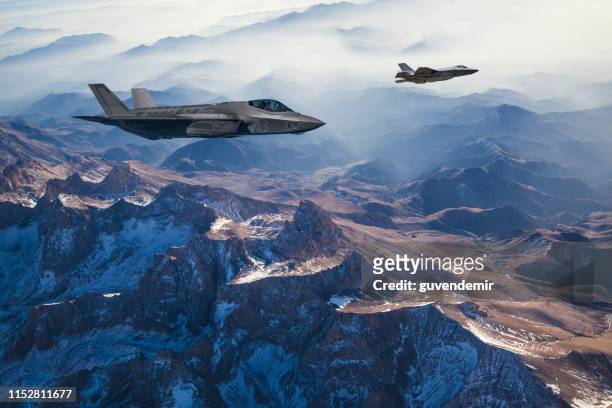 aviones de combate volando sobre las montañas al atardecer - industria de la defensa fotografías e imágenes de stock