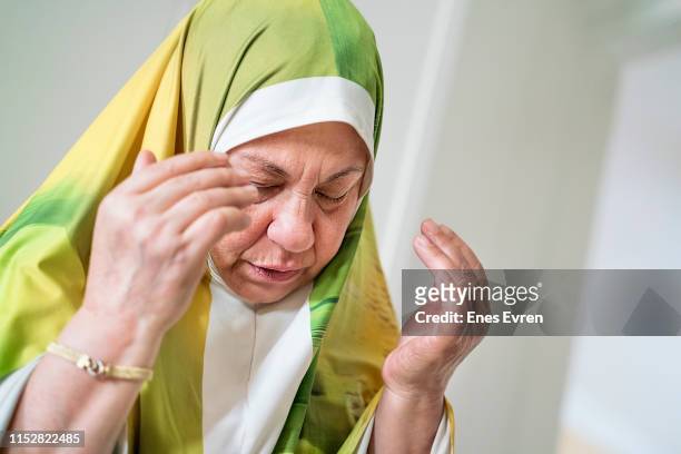 ritratto di un'anziana donna musulmana che prega - abbigliamento religioso foto e immagini stock