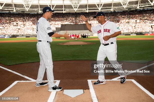 Manager Aaron Boone of the New York Yankees shakes hands with manager Alex Cora of the Boston Red Sox before game one of the 2019 Major League...