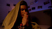 Religious teenager praying covered with blanket, belief in god, sectarianism