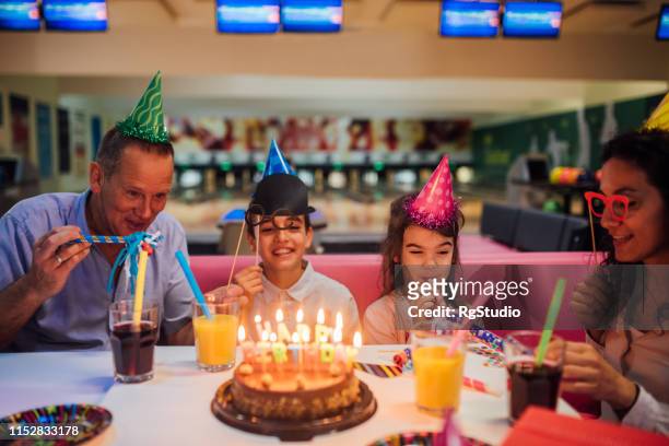 family celebrating birthday together - bowling party stock pictures, royalty-free photos & images