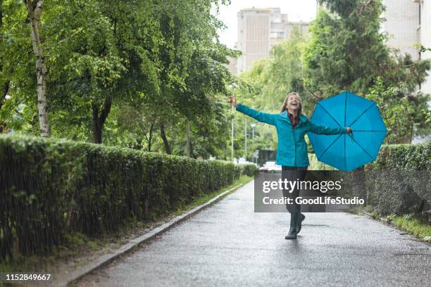 young woman dancing in the rain - umbrella rain dancing stock pictures, royalty-free photos & images