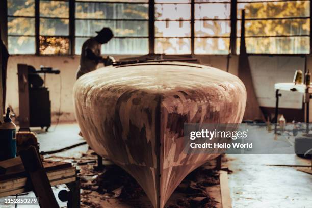 man sanding wooden power boat building project - restauratiestijl stockfoto's en -beelden