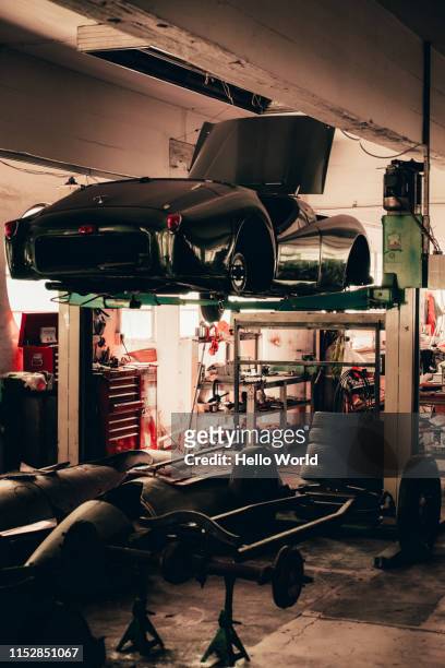 classic vintage car hoisted on a hydraulic jack - old car garage stock pictures, royalty-free photos & images