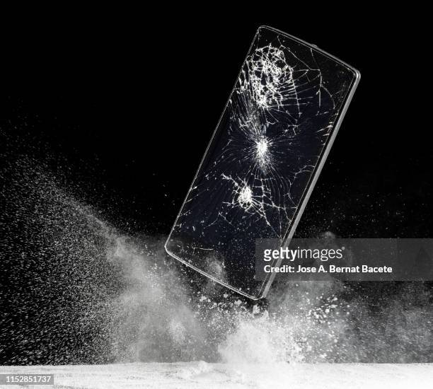 mobile phone with broken glass falls to the ground. - broken smartphone fotografías e imágenes de stock