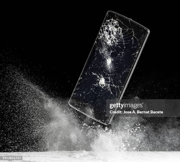 mobile phone with broken glass falls to the ground. - exploding glass 個照片及圖片檔