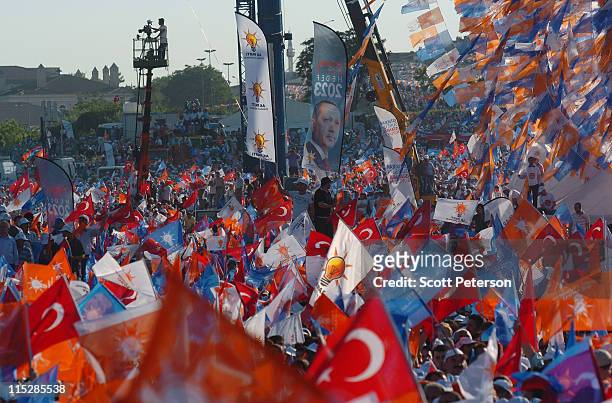 Strings of Turkish and party flags fly beside a banner of Turkey's leader, as thousands of Turks rally to hear Turkey's Prime Minister Recep Tayyip...