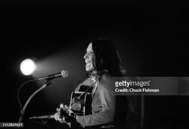 American folk musician Buffy Sainte-Marie plays guitar as she performs onstage during a concert at the Northern Illinois University fieldhouse,...