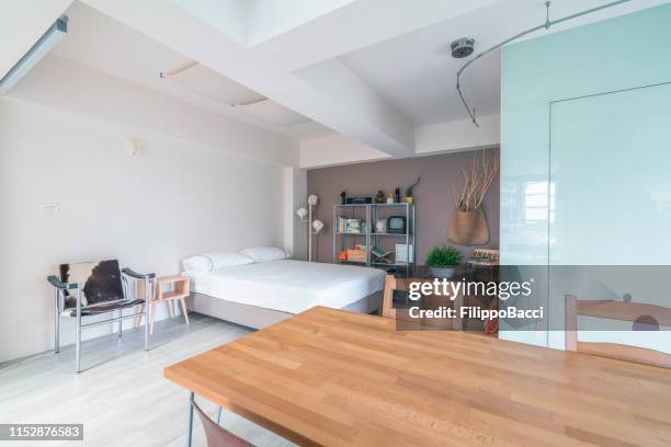 open space interior with a bedroom corner - studio apartment stock pictures, royalty-free photos & images