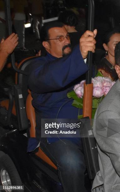 Hollywood actor Steven Seagal and his wife Erdenetuya Seagal are on their way to a private village by a caddie cart following their arrival on an...