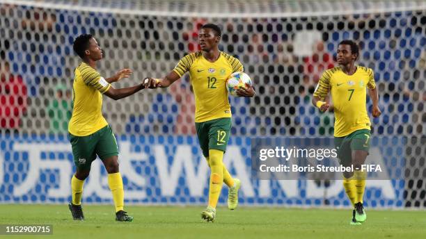 James Monyane of South Africa celebrates with team mates Kobamelo Kodisang of South Africa and Promise Mkhuma of South Africa after scoring his...