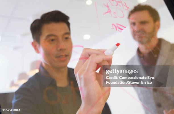 co-workers brainstorming in modern office - whiteboard writing stock pictures, royalty-free photos & images