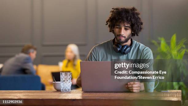 creative businessman using laptop in co-working space - black man laptop photos et images de collection