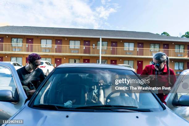 June 27: Living in an extended stay budget hotel because they cannot afford or find affordable housing, Aja Mallow, center, walks with her mother,...