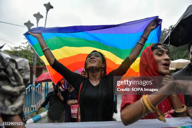 Community member celebrates while holding a rainbow coloured flag as he takes part during the pride march to mark the 20th anniversary of the first...