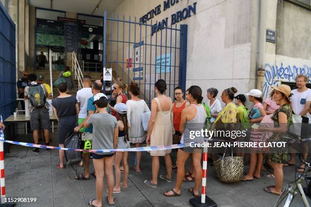 Security personnel and municipal police officers check the bags of people entering the Jean Bron swimming pool in Grenoble, central-eastern France,...