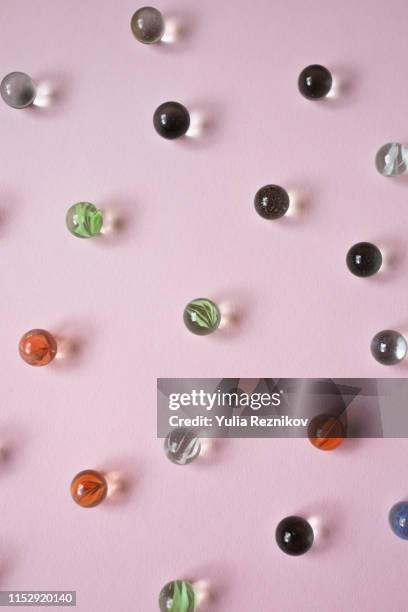 marble balls on the pink background - murmel stock-fotos und bilder