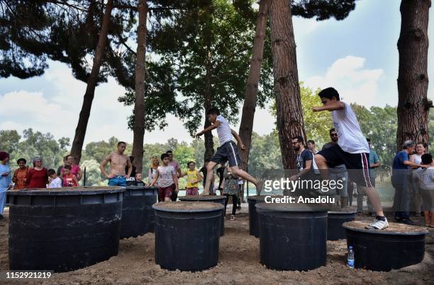 Kids compete in the obstacle racing track organized by using tin, tire, wood, bucket, slides, mud and net in Tarsus district of Mersin, Turkey on...