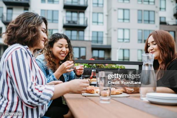 group of latina friends eat on outdoor patio - restaurant women friends lunch stock pictures, royalty-free photos & images