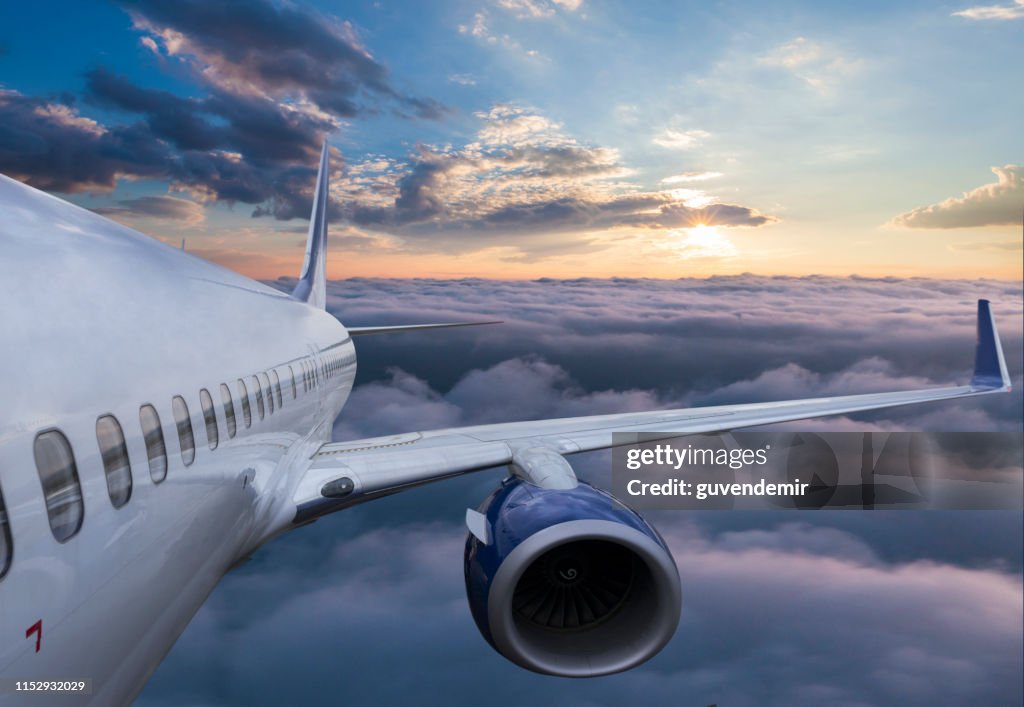 Body of an Airplane Flying Through Clouds at sunset