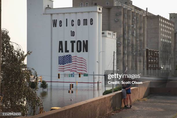 Couple takes a picture on a building overlooking an area flooded by the Mississippi River near the historic downtown on May 31, 2019 in Alton,...