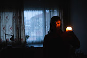 Woman with candle at home because of power cut